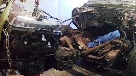 Hoisting the Pontiac's 350 engine out of the engine bay.